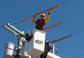 Technician in a bucket lift repairing electrical wires