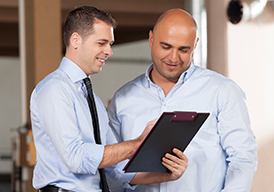 Two men looking at a clipboard
