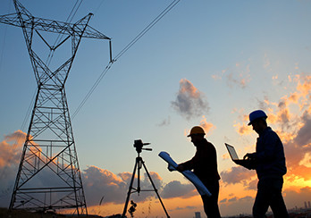 Utility surveyors standing under power lines