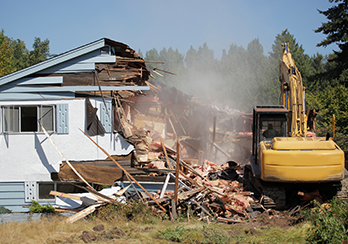 Construction equipment demolishing house