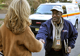 Back of woman who's shaking the hand of a service worker