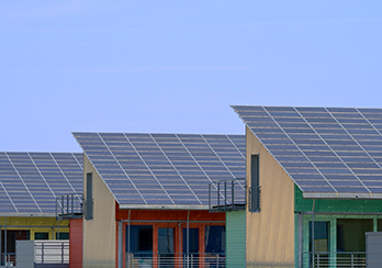 Solar panels installed on a series of buildings with slanted roofs
