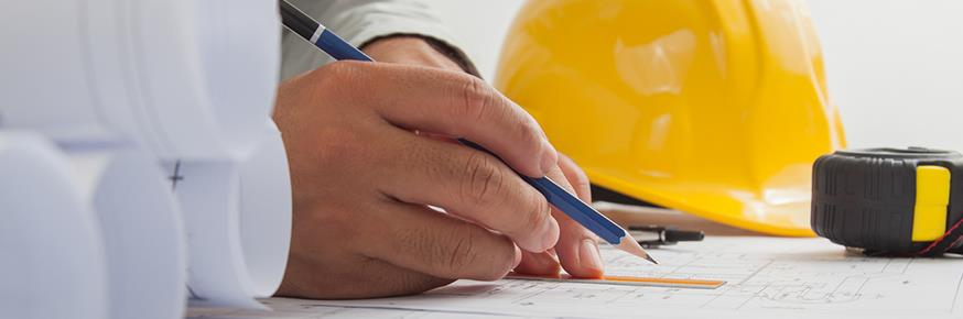 Closeup of hands marking up a blueprint with a pencil