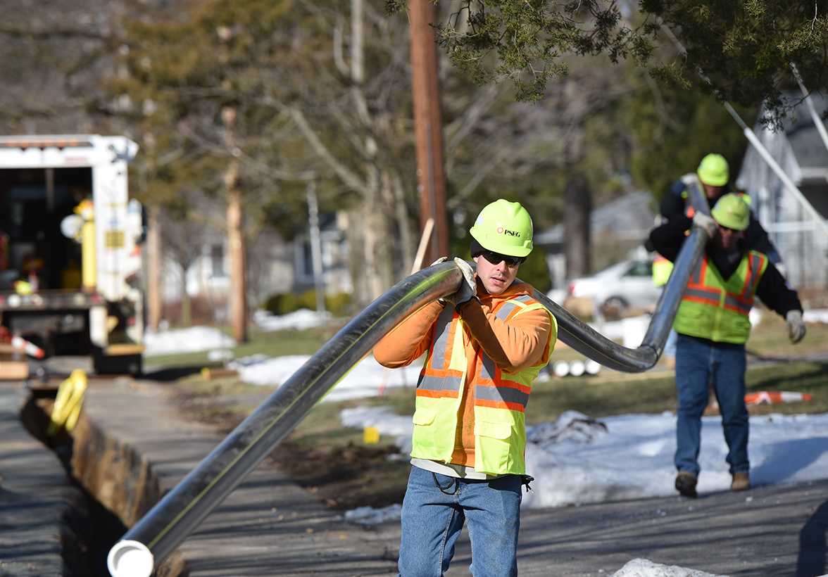 PSE&G workers carrying a gas pipe
