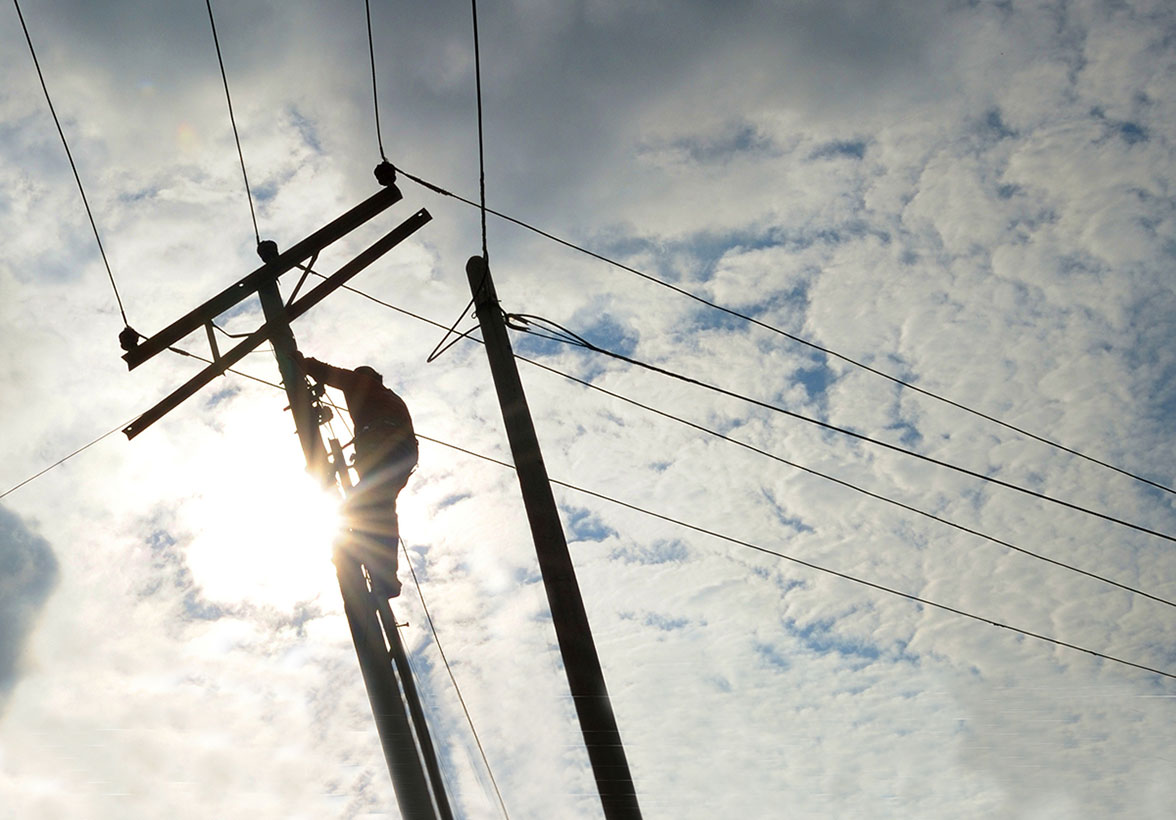 Utility worker in elevated bucket working on power lines