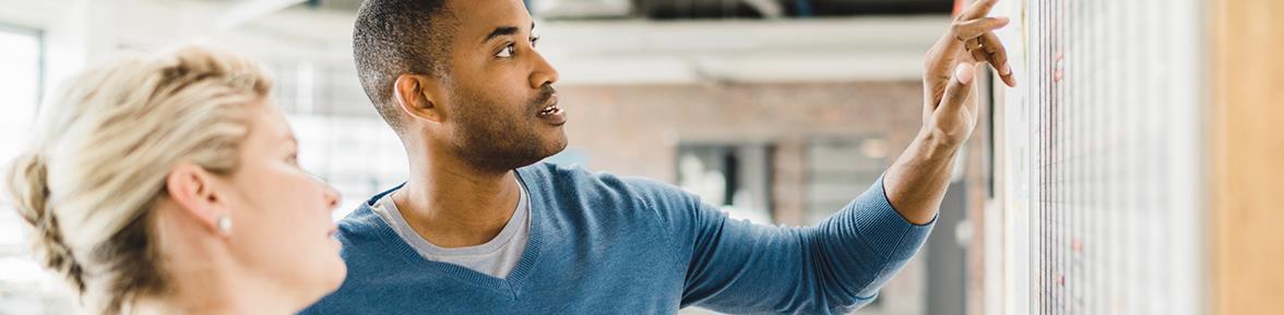 Man and woman looking at a wall chart in a partially-constructed building