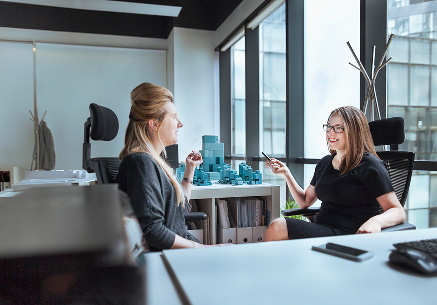 Two women having a conversation in an office.