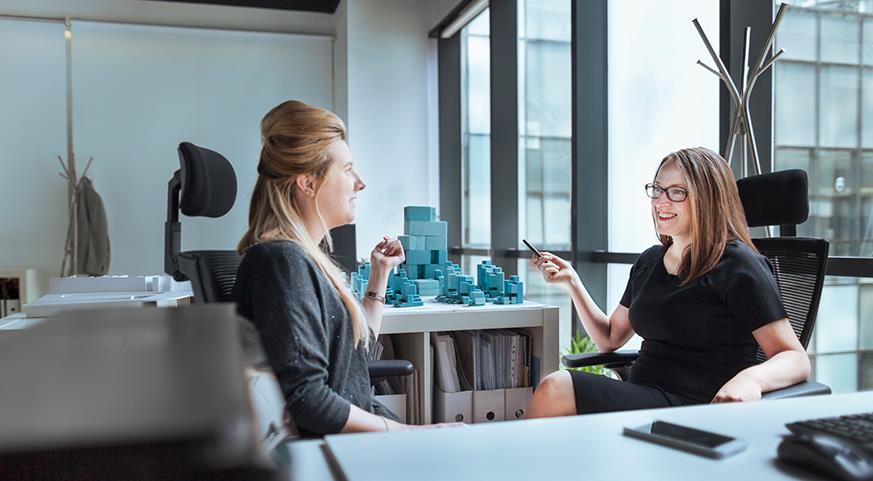 Two women having a conversation in an office.