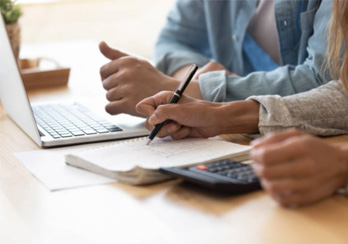 A couple working at a laptop, paying utility bills.