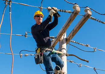 A technician working on elevated power lines