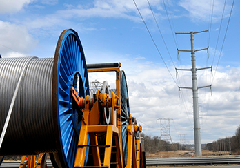 Coils of unused electrical cable on the ground beneath power transmission lines