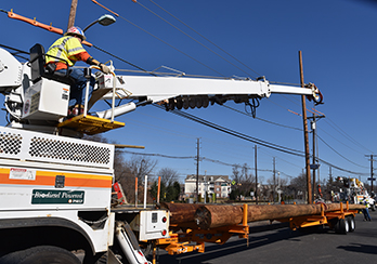 Crane on PSE&G truck lifting electrical pole for installation