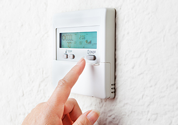 Finger touching programmable thermostat