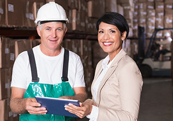 Man wearing hardhat and woman standing in a partially-constructed building