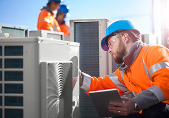 Utility worker examining an HVAC unit