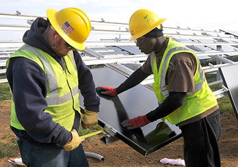 Two workers assembling solar modules