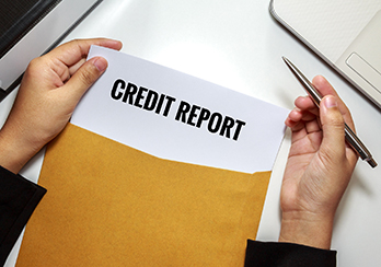 Hands holding a paper titled Credit Report