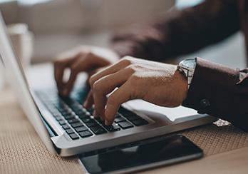 Hands typing on a computer keyboard