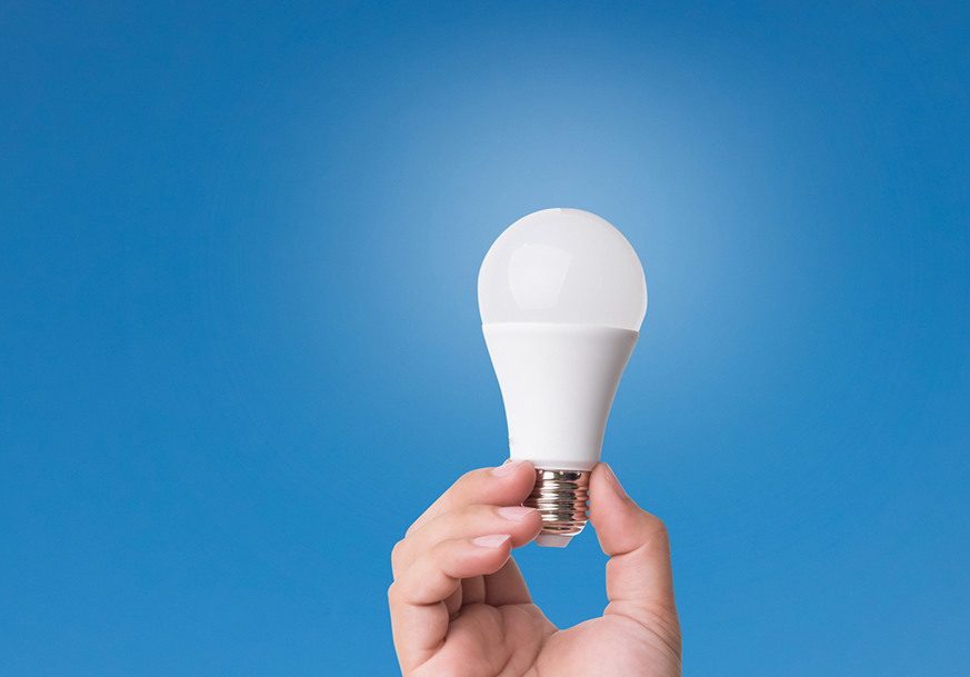 A hand holding a lightbulb