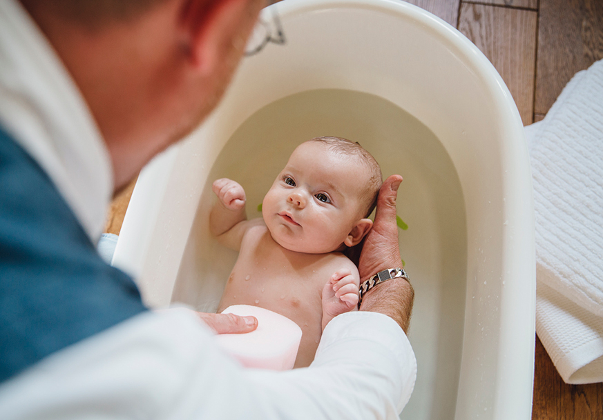 A father bathing an infant