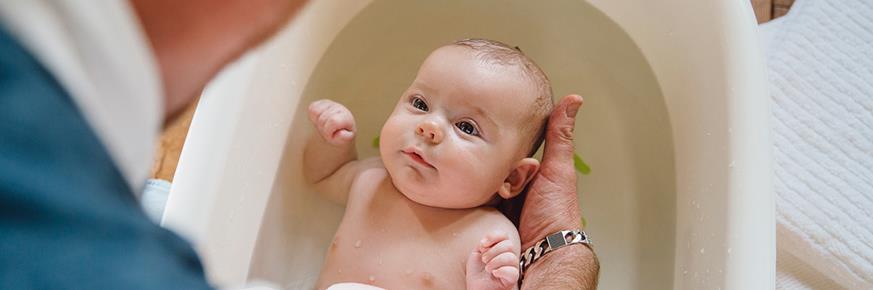 A father bathing an infant