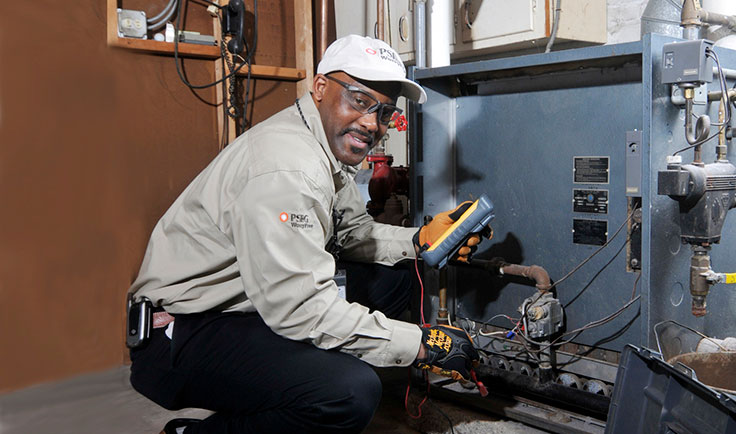 PSE&G technician servicing equipment inside someone's home